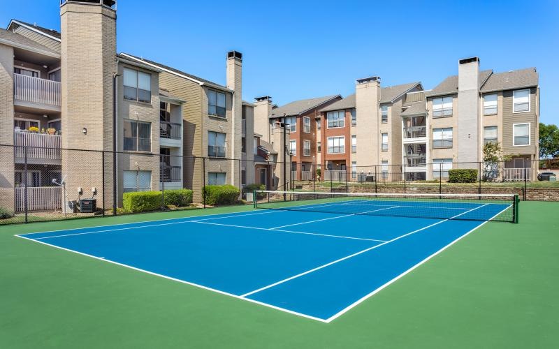 a tennis court in front of a building